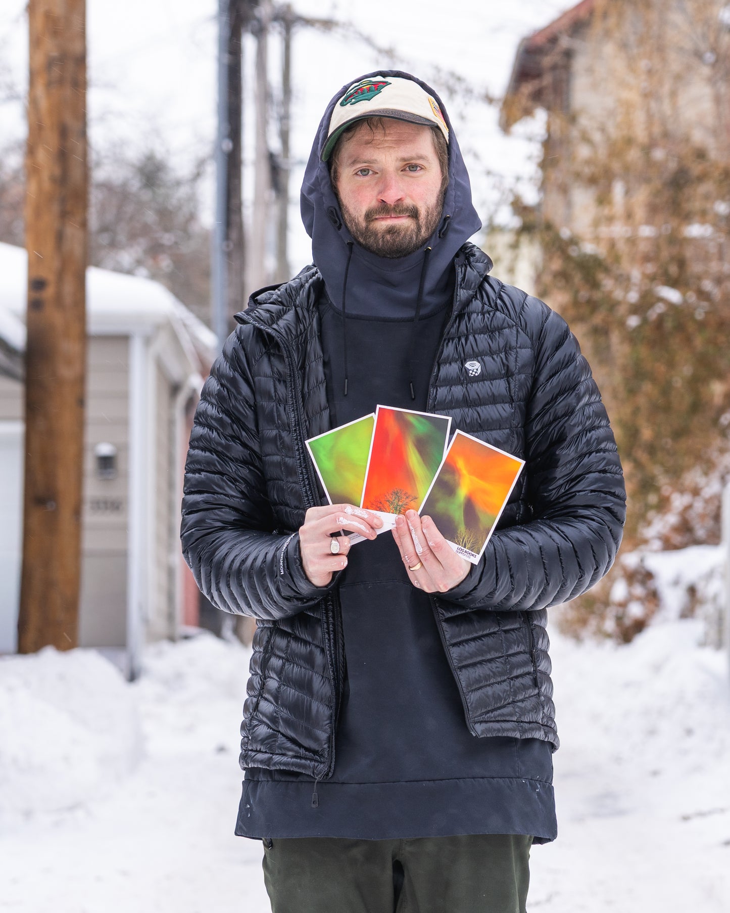 Man holding colorful cards in a snowy outdoor setting